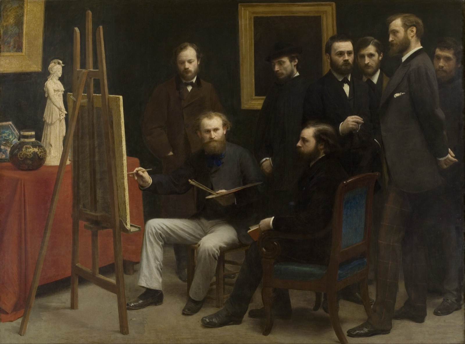 Dans un atelier sombre, un peintre barbu assis devant son chevalet peint un homme assis ; huit hommes en costume sombre se tiennent debout autour d'eux et regardent