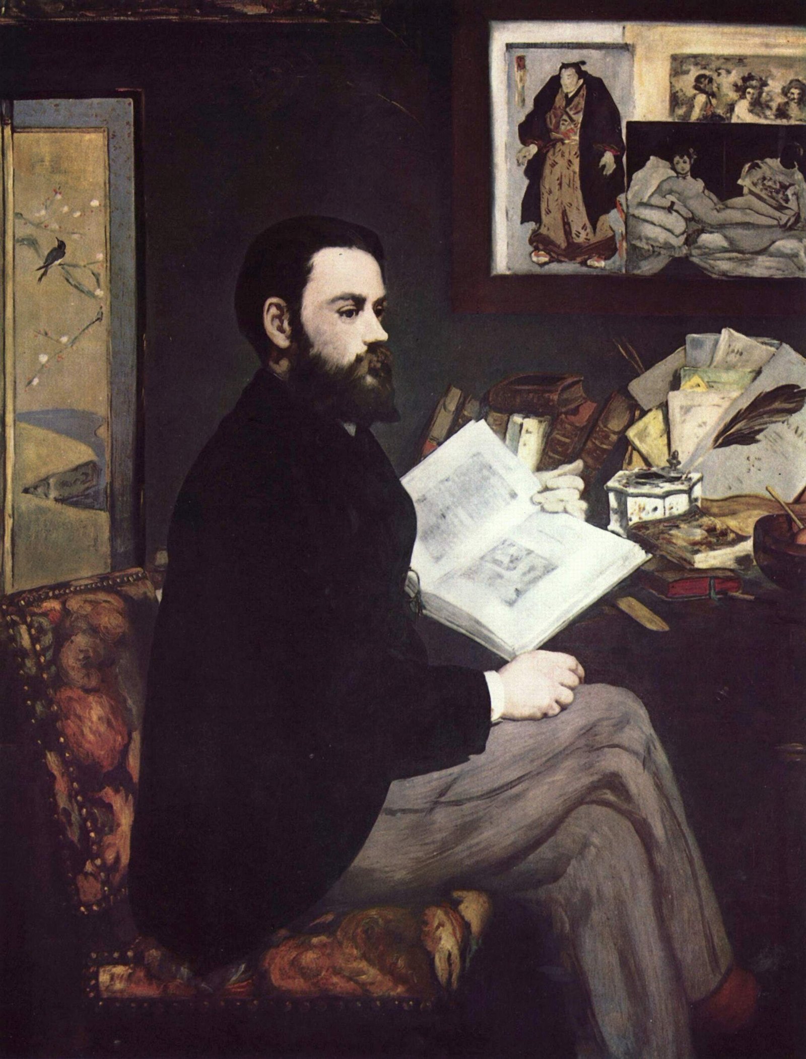 Un homme barbu en veste noire, assis de profil près d'une table encombrée de livres, feuillette un grand volume ; au mur, des estampes, dont une reproduction d'Olympia
