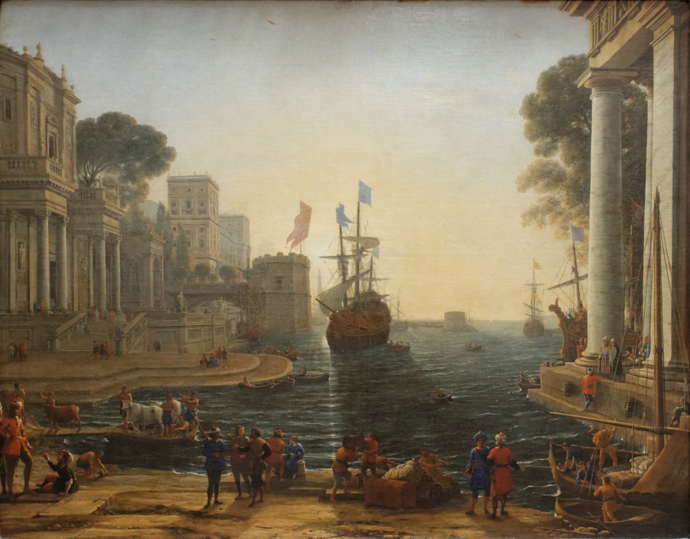 Un port au soleil couchant, bordé de palais à colonnades ; au centre un grand navire, au premier plan des personnages qui débarquent
