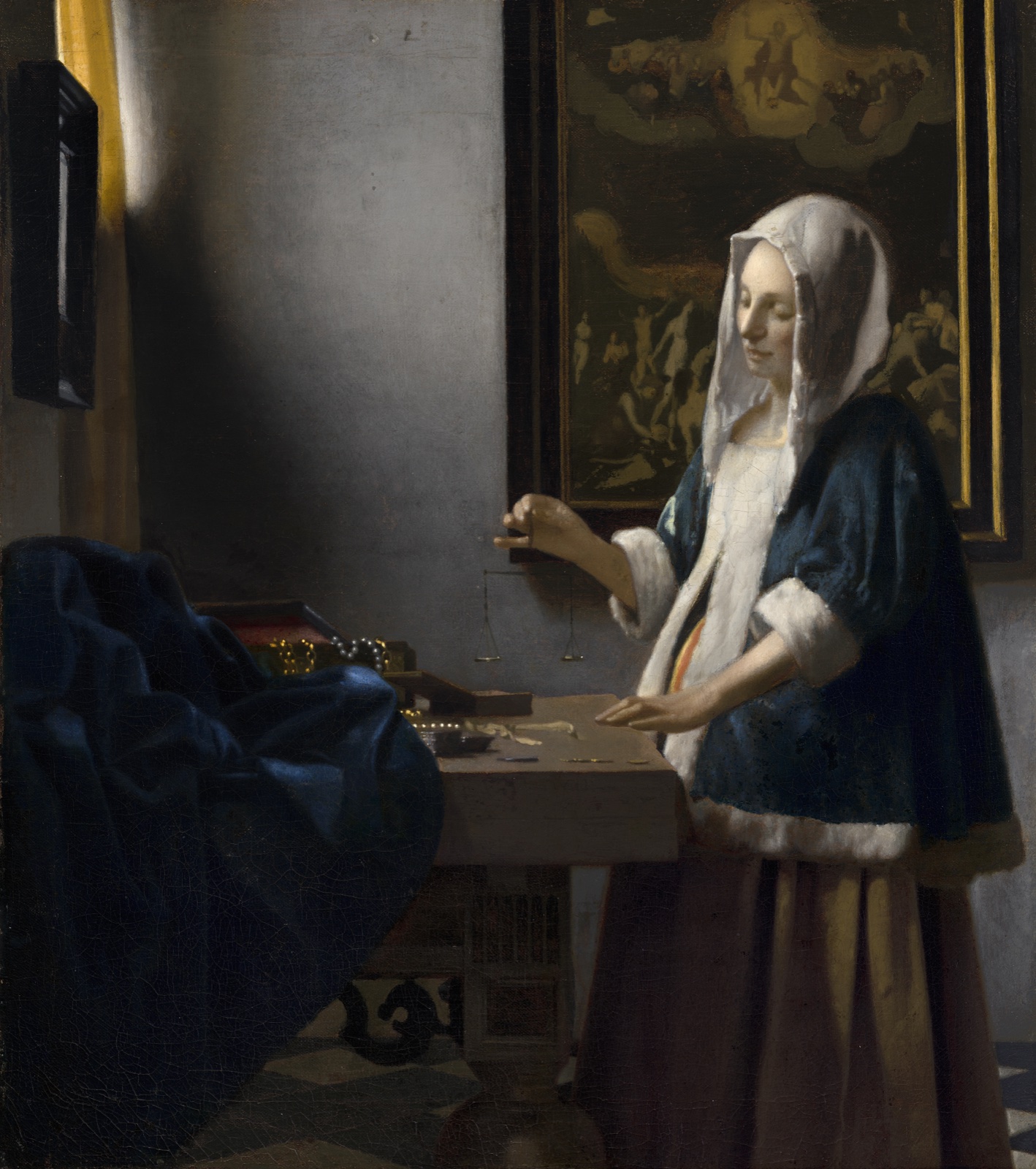 Dans une pièce sombre éclairée par une fenêtre, une jeune femme tient une petite balance au-dessus d'une table couverte de perles et de pièces