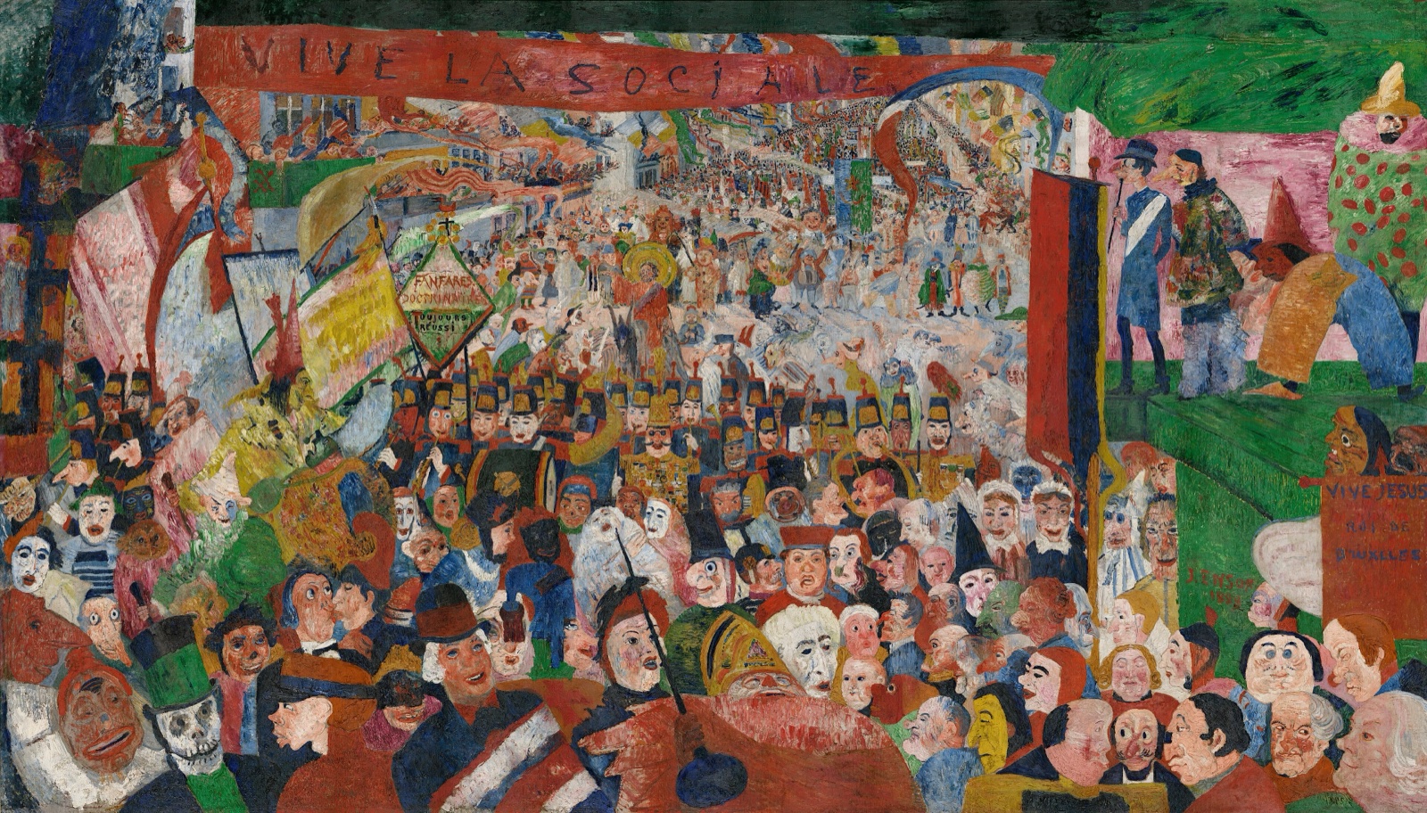 Une foule immense et bariolée de visages-masques envahit une avenue sous des bannières et des slogans ; au loin, minuscule, le Christ sur un âne