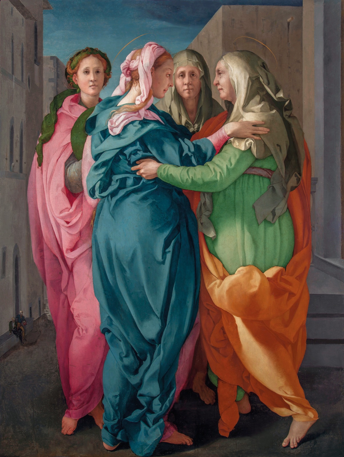 Dans une rue à l'architecture dépouillée, deux femmes aux manteaux bleu et orange s'étreignent, pendant que deux autres, de face, regardent le spectateur