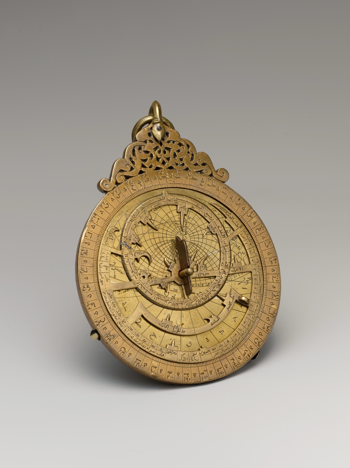 Astrolabe en laiton doré : un disque gravé d'inscriptions et de graduations, surmonté d'un anneau de suspension ajouré